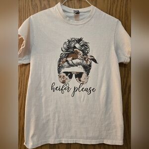 Light tan, short sleeve graphic t shirt with "Heifer Please" on the front.